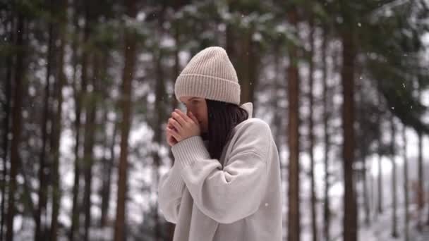 귀여운 아이가 숲에서 뜨거운 커피를 마시고 내리고 베이지 모자와 재킷을 — 비디오