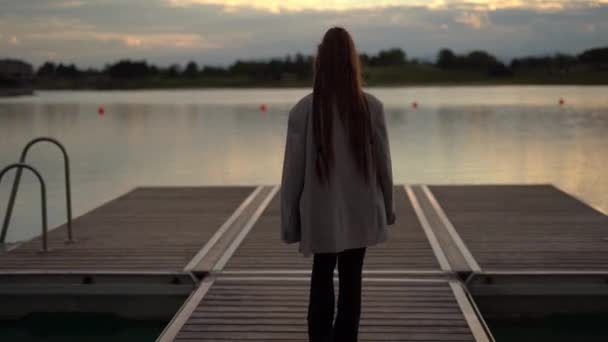 后视镜上的女人带着辫子走在平台上 湖面上 夕阳西下 高质量的4K镜头 — 图库视频影像