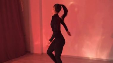 Sexy girl is dancing in studio with red light, slow motion footage. High quality FullHD footage