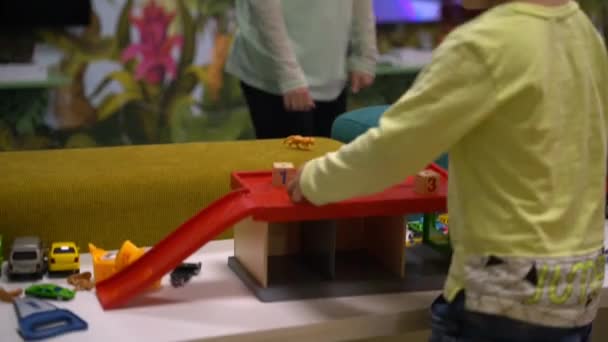 Yaşında Bir Çocuk Beyaz Bir Masanın Üzerinde Arabalarla Oynuyor Çizgi — Stok video