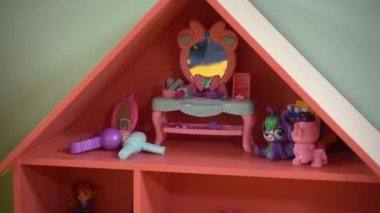 Toy pink house with dolls, hair dryer, mirror at home. High quality FullHD footage