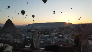 Goreme 'de bir kız çok sayıda balonun ortasında yürüyor. Yüksek kaliteli FullHD görüntüler