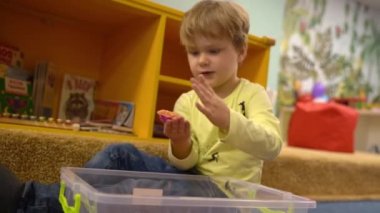 A child 5 years learns to build figures with kinetic sand in children room . High quality FullHD footage