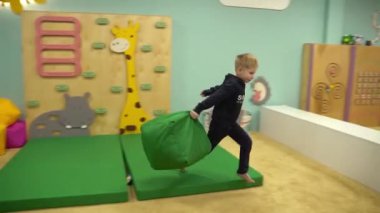 Mariupol, Ukraine 17 December 2021: A boy throws colorful pillows at a childrens club. High quality FullHD footage