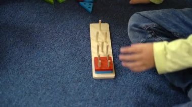 Boy 5 years works with puzzles sitting on the floor. Close up view on hands. High quality FullHD footage