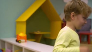 A boy holding a box of toys. The child is running. High quality FullHD footage