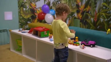 Boy playing with cars indoors. High quality FullHD footage