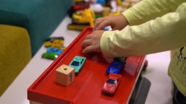 The boys hands play cars in the parking lot indoors. High quality FullHD footage