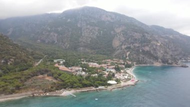 Beyaz gökyüzü ve kumsal manzaralı büyük dağlar ve Fethiey 'de evler. Yüksek kalite 4k görüntü