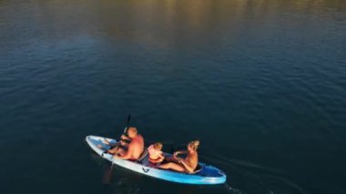 People are swimming in a blue kayak. Close-up from drone. High quality 4k footage