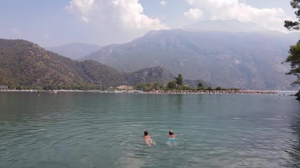 一个男人和一个女孩在蓝色的湖岸上游泳 高质量的4K镜头 — 图库视频影像