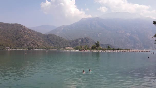 无人机发射 一个男人和一个女孩在蓝色的湖岸上游泳 高质量的4K镜头 — 图库视频影像