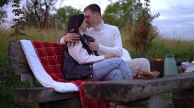 People Enjoying nature outdoor. Beautiful couple relaxing and drinking in nature place over sunset. . High quality 4k footage