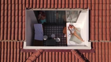 Oludeniz Oteli 'nin çatısında güneş gözlüklü bir kadının jakuzide yattığı ve adamın fotoğraf çektiği hava görüntüsü. Yüksek kalite insansız hava aracı FullHD görüntüleri, güzel panoramik manzara, kadın tatilde dinleniyor., 