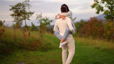 Couple holding carrying spinning woman having fun enjoy in nature, sunset, Relax in nature. High quality 4k footage