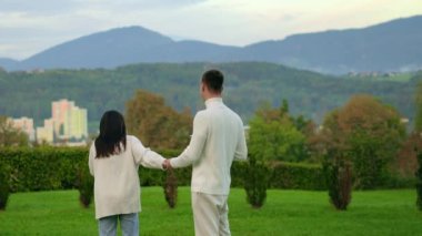 Young couple in white clothes stay mountains background drink tea, talk each other. High quality 4k footage