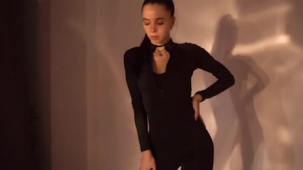 Σέξι Κοπέλα Μαύρα Ρούχα Που Χορεύει Στο Στούντιο Φόντο Φως — Αρχείο Βίντεο