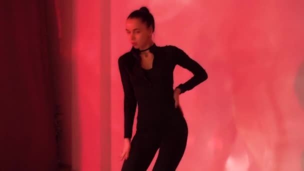 穿着黑色衣服的性感女孩在橙色霓虹灯的背景下跳舞 在工作室里跳舞 慢动作 优质Fullhd影片 — 图库视频影像
