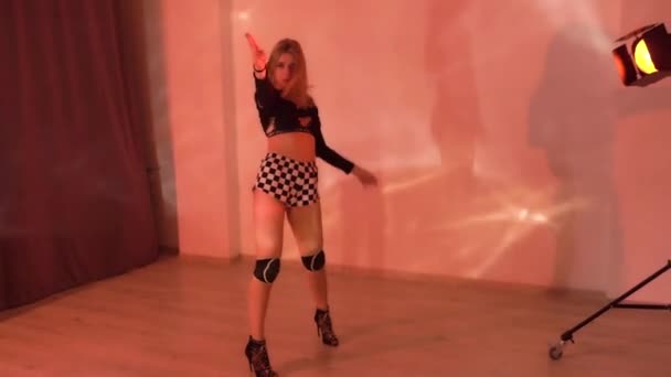 穿着高跟鞋格子花短裤的性感女孩和跳舞的膝盖垫在工作室里跳色情舞 优质Fullhd影片 — 图库视频影像