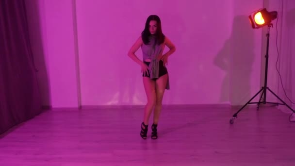 チョーカーと黒のハイヒールを着たセクシーな女の子が赤いライトアップのスタジオで床の上で踊っています 高品質のフルHd映像 — ストック動画