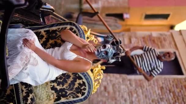 在意大利威尼斯的贡多拉 一个身穿白色礼服 戴着狂欢节面具的漂亮女人正在乘坐垂直录像 高质量的4K镜头 — 图库视频影像