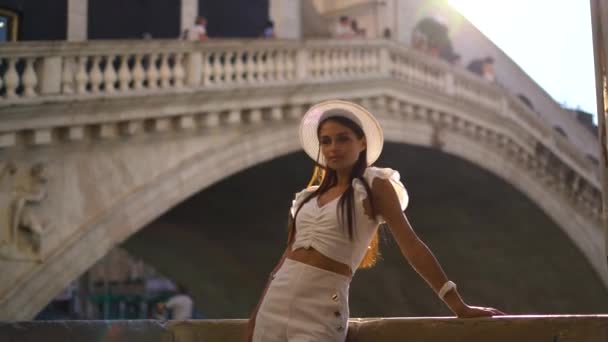 身着白衣的年轻女子在意大利威尼斯的桥旁悠闲地站着 夕阳西下 高质量的4K镜头 — 图库视频影像