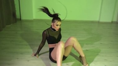 Üstte ve şeffaf kısa taytlı seksi kadın renkli ışıklı odada yerde dans ediyor. Yüksek kaliteli FullHD görüntüler
