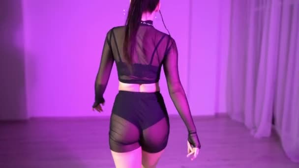 透明な短いレギンスでセクシーな女性とトップがカラフルな照明室で床の上で踊っています 高品質のフルHd映像 — ストック動画
