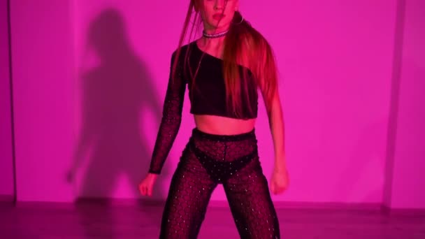 トップダンスとダンスパンツの誘惑的な女の子が照明付きのスタジオルームの床で踊っています 高品質のフルHd映像 — ストック動画