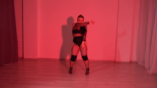さらに黒透明な作物の上のモデルダンサーの女の子が赤いライトアップのスタジオルームで踊っています 高品質のフルHd映像 — ストック動画