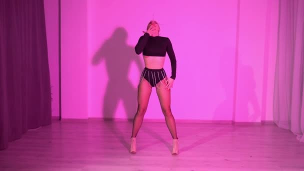 透明な短いレギンスとピンクの照明の部屋で床の上のダンスで魅惑的な女性 高品質のフルHd映像 — ストック動画