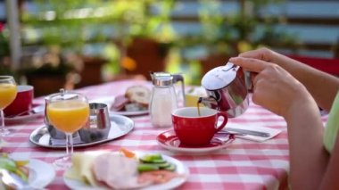 Doğadaki Hallstatt Cafe 'de kahveye kahve koyan yakın plan kadın, kahvaltı zamanı. Yüksek kalite 4k görüntü