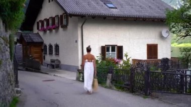 Kadın Hallstatt 'ün Köyleri caddesinde yürüyor. Yüksek kalite 4k görüntü