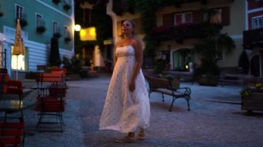 Kadın gece vakti Hallstatt caddelerinde yürüyor. Yüksek kalite 4k görüntü