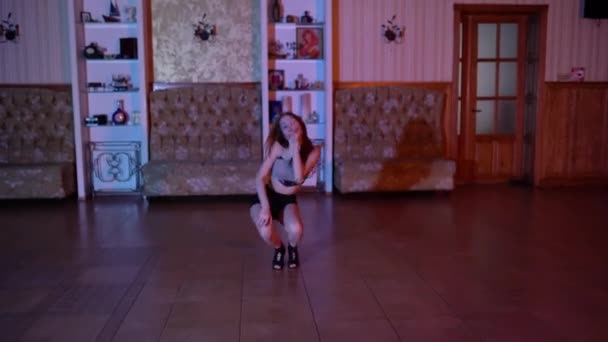 セクシーなブルネットの女性は黒い乙女のランジェリーと床の上のハイヒールで踊ります 高品質4K映像 — ストック動画