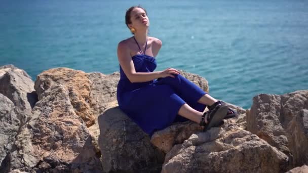 Dziewczyna Siedzi Kamieniach Plaży Oceanicznej Odpoczywając Tropikalnym Kurorcie Wysyła Pocałunek — Wideo stockowe