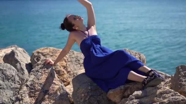 Mavi Elbiseli Kız Okyanus Sahilinde Taşların Üzerinde Oturur Tropikal Tatil — Stok video