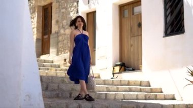 Mavili kız İbiza 'nın merdivenlerinde yürüyor, dönüyor ve eğleniyor. Yüksek kalite 4k görüntü