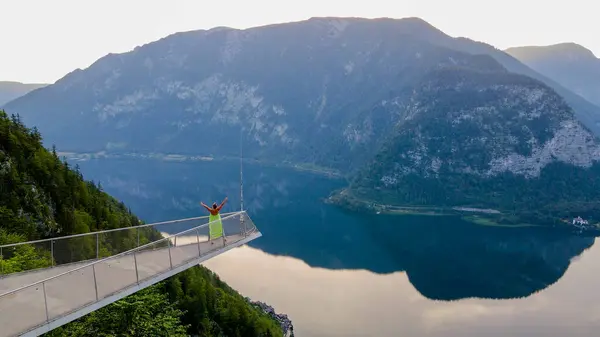 Elbiseli kadın, Alpler ve Hallstatt Gölü manzaralı izleme platformunda duruyor. Yüksek kalite fotoğraf