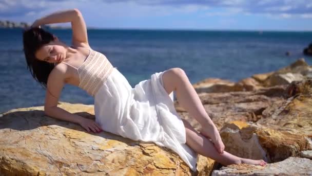 Menina Vestido Branco Sol Basking Pedra Quebra Mar Sorrindo Desfrutando — Vídeo de Stock