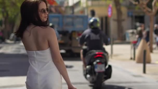 戴太阳镜的女孩走在Ibiza街上 看着摄像机 高质量的4K镜头 — 图库视频影像