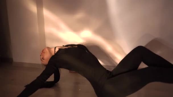 穿着黑色衣服 身披高跟鞋 身材苗条的年轻女子在地板上跳舞 动作缓慢 优质Fullhd影片 — 图库视频影像