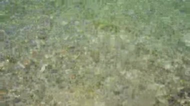 Yakından temiz su akıyor. Güzel mavi berrak göl suyu, gölet, hareket eden deniz. Su dalgalarının yüzeyindeki ışığın yansımaları. 4 bin. Yüksek kalite 4k görüntü