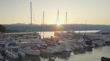 Gün batımında gökyüzü altın rengine döndüğünde limandaki rıhtıma demirlemiş çok sayıda su botu nakliye merkezinde güzel bir manzara yaratıyor.