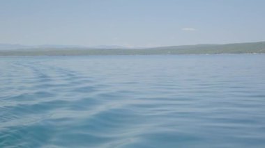 Mavi deniz suyu arka planının ve güneş yansımalarının havadan görüntüsü. Uçan İHA görüntüsü. Dalgalar su yüzeyinde. Okyanus üzerinden uçmak. Havadan okyanus manzaralı. Denizin üstünde uçuyor. - Evet. Yüksek kalite 4k görüntü