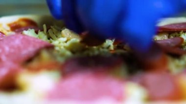 Aşçı kadın pizza hamuruna sosis koyuyor, hamur malzemelerini İtalyan pizzası yapma sürecine koyuyor, yakın plan pişirme kavramını hamur üzerine koyuyor. Yüksek kaliteli FullHD görüntüler