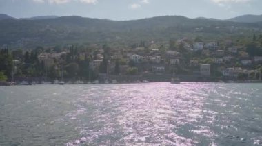 Güneşli dağları olan bir sahil kasabası, dinlenmek ve manzarayı izlemek için sakin ve çarpıcı bir ortam sağlıyor.