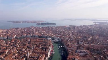 Şehrin su ve çatı üzerindeki hava manzarası bazilikanın çan kulesi ve Venedik ve İtalya 'yı geçen tekneli benzersiz kanallar. Turistli gondollar. Yüksek kalite 4k görüntü