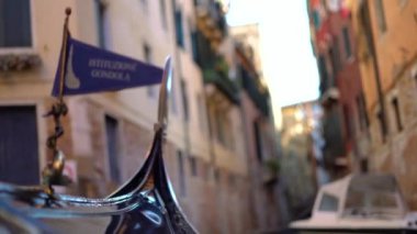 Güzel tarihi binaların arasında zarif bir şekilde hareket eden bir gondol gösteren büyüleyici ve resimli bir Venedik kanal sahnesi.