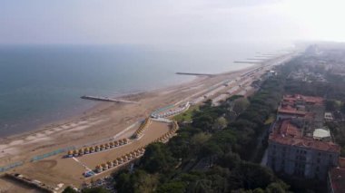 Sakin bir plajın nefes kesici hava manzarası, geniş sahil şeridini ve manzarayı güzelleştiren özellikleri gösteriyor.